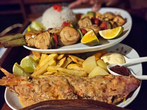 two plates of food with fish and french fries at KINTANA LODGE in Ile aux Nattes