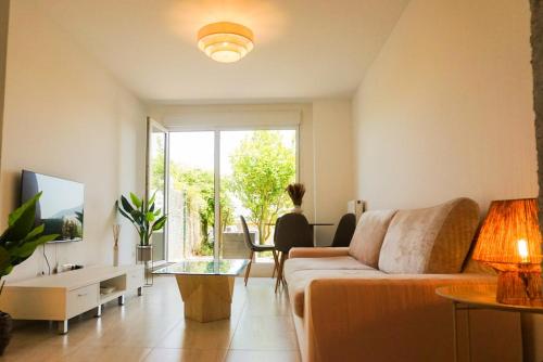 a living room with a couch and a glass table at Bajo con jardines cerca de la playa in Miengo