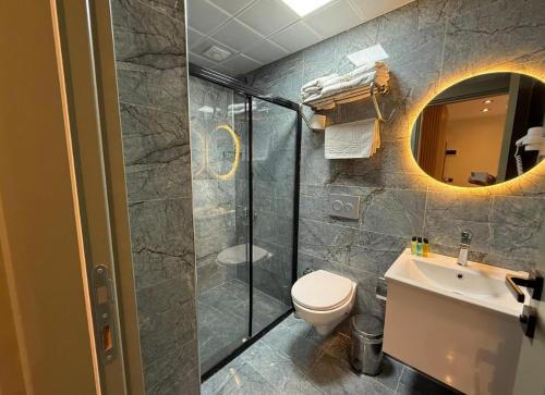 a bathroom with a shower and a toilet and a sink at Siya Boutique Hotel in Batman