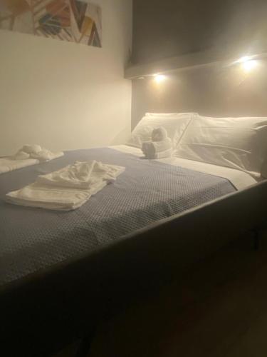 a unmade bed with a pile of towels on it at B&B al Vicoletto in Bellante
