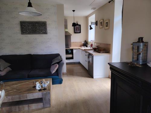 un salon avec un canapé et une cuisine dans l'établissement La maison o kiwis, à Saint-Denis-lès-Martel