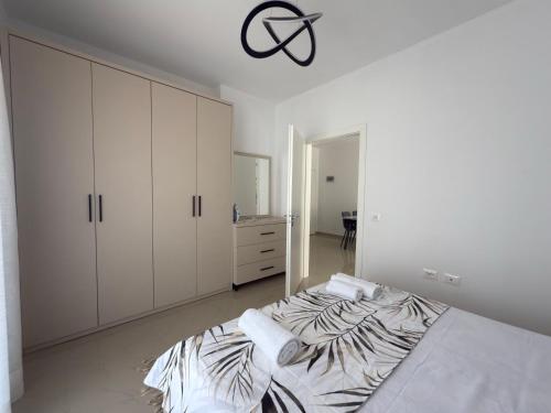 1 dormitorio blanco con 1 cama y vestidor en Rei Apartments 3, en Lezhë