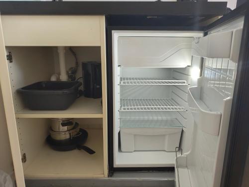 an empty refrigerator with its door open in a kitchen at WHLIVING - Apartments & Studios in Konstanz in Konstanz