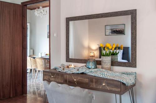 a living room with a mirror and a table with yellow tulips at Join In Home in Pogoniá