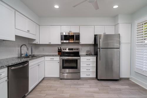 a kitchen with white cabinets and stainless steel appliances at 1147 Summerwind Cottage in Seabrook Island