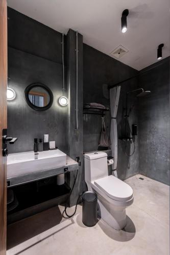 a bathroom with a white toilet and a sink at Boss Level Gaming Hotel in Rawai Beach