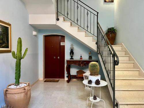 a hallway with a staircase with a cactus and a table at Terre Saracene Suites in Bitonto