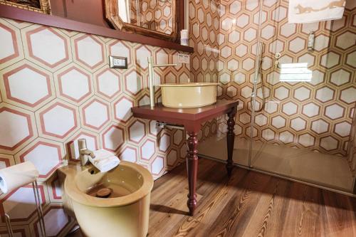 a bathroom with a toilet and a small table at Agriturismo Le Volpi in Baone