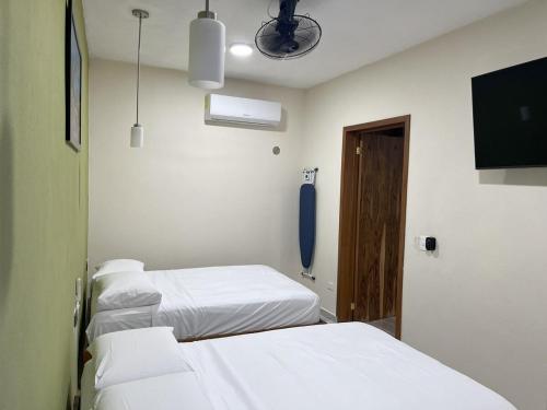 a hospital room with three beds and a tv at Depa Caribe III in Bacalar
