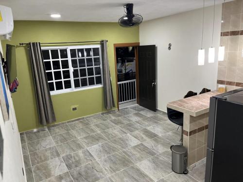 a kitchen with green walls and a tile floor at Depa Caribe III in Bacalar