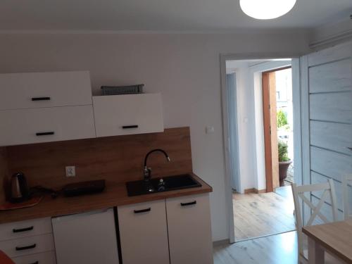 a kitchen with white cabinets and a sink at Przystanek Dąbki in Dąbki