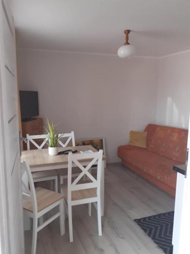 a living room with a table and a red couch at Przystanek Dąbki in Dąbki