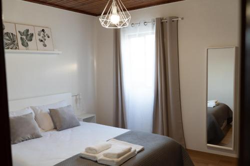 a bedroom with a bed with two towels on it at Geres Andorinhas House in Vieira do Minho