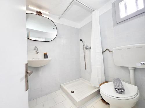 a white bathroom with a toilet and a mirror at L'Ora Blu in Marathokampos