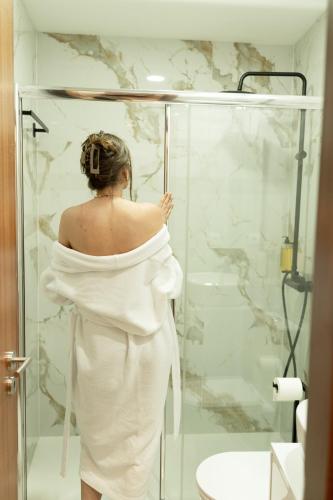 a woman in a white dress standing in a shower at Geres Andorinhas House in Vieira do Minho