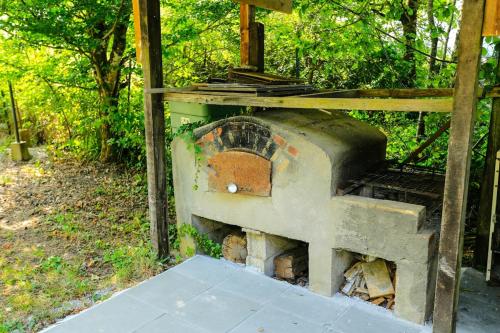 an old brick oven sitting in the woods at Le Chalet de la Forêt, ideal for your reunions in Guewenheim