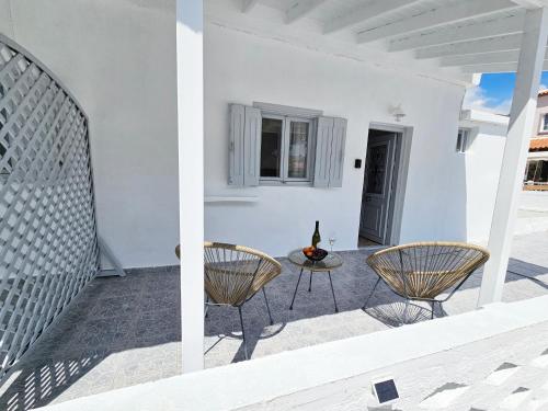 a patio with two chairs and a table at L'Ora Blu in Marathokampos