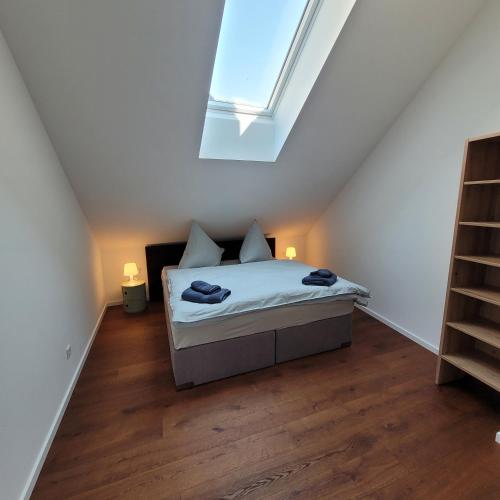 a small bedroom with a bed with a skylight at Scheune Am alten Posthof Lieser in Lieser