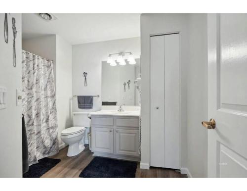 a white bathroom with a toilet and a sink at Highland Estates Condotel in Mesquite