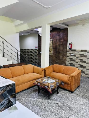 a living room with a couch and a coffee table at Hotel Victoria INN in Sohāna