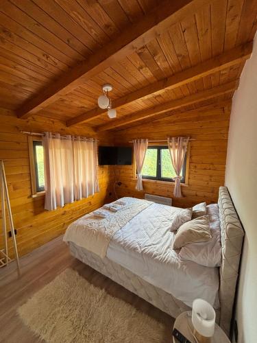 a bedroom with a bed in a wooden cabin at Planinska kuća SAMAK in Sarajevo