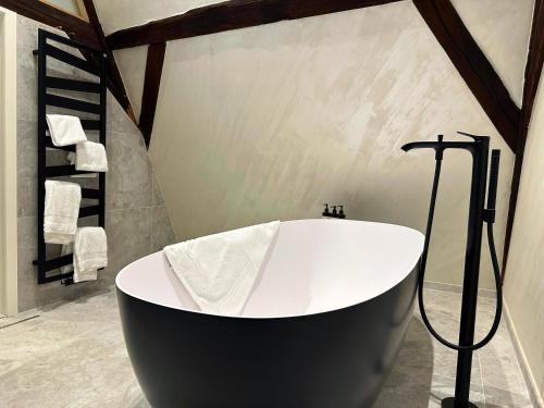 a black and white bath tub in a bathroom at Van Der Valk Sélys Liège Hotel & Spa in Liège