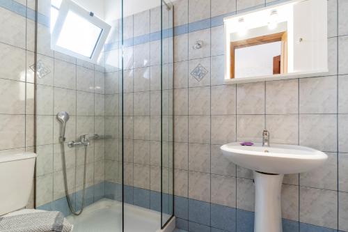 Un baño con lavabo y ducha de cristal. en Kastro Kera, en Almyrida