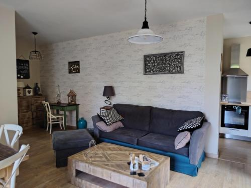 a living room with a couch and a table at La maison o kiwis in Saint-Denis-lès-Martel