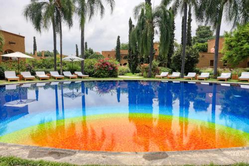 a pool with a rainbow in the water at Mision del Sol Resort & Spa Adults Only in Cuernavaca