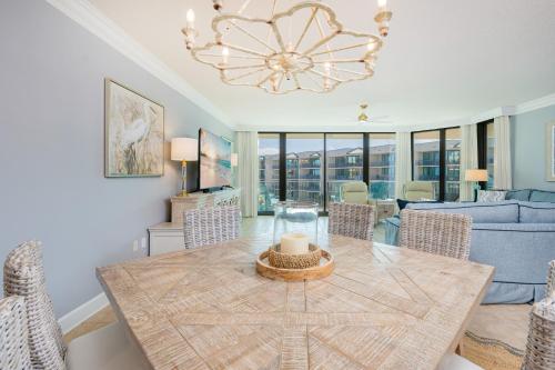 ein Wohnzimmer mit Tisch und Couch in der Unterkunft Phoenix on the Bay 1428 condo in Orange Beach