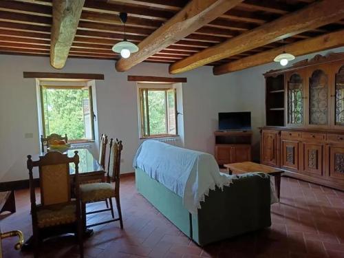 una sala de estar con una cama y una mesa en Casa dell Ulivo, en Castiglion Fiorentino