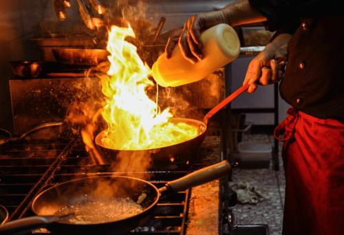 a person cooking food in a pan on a grill at Slot603 in Ciloto