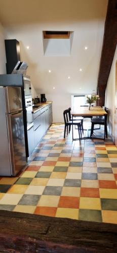 - une cuisine avec un sol en damier et une table avec des chaises dans l'établissement Hôtel Restaurant La Terrasse, à Saugues