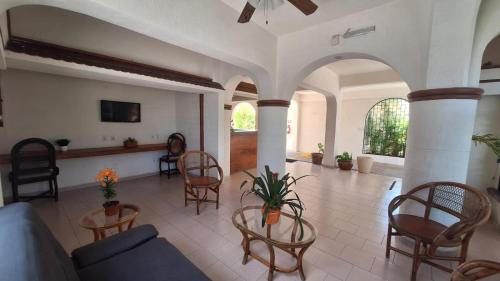 a living room with a couch and chairs at Capital O Hotel Rolovi Cancún in Cancún