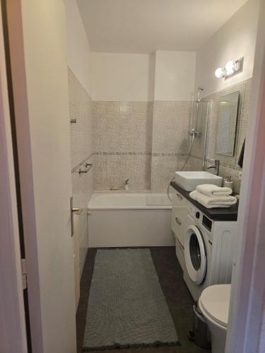 une salle de bain avec une baignoire, un lavabo et des toilettes dans l'établissement Fully-equipped large studio with terrace, à Rueil-Malmaison