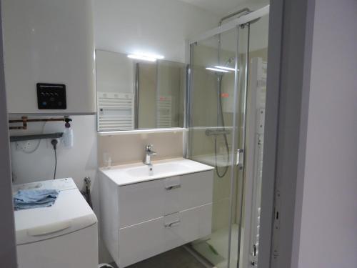 ein weißes Badezimmer mit Waschbecken und Dusche in der Unterkunft victoria in Eaux-Bonnes