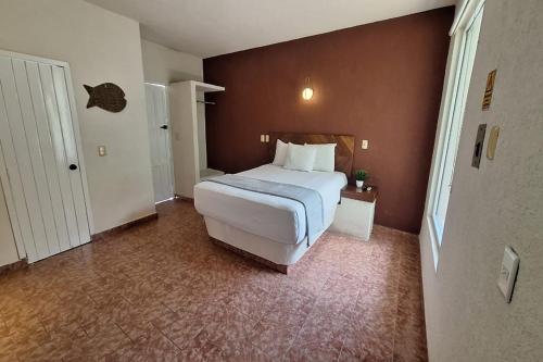 a bedroom with a large bed in a room at Capital O Hotel Rolovi Cancún in Cancún