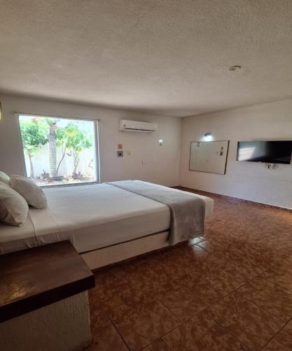 a large bedroom with a large bed and a window at Capital O Hotel Rolovi Cancún in Cancún