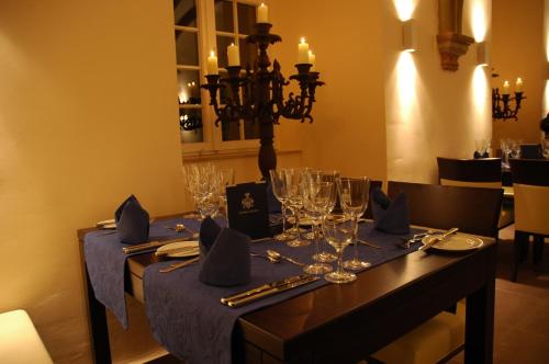 GehrdenにあるHotel Schloß Gehrdenのダイニングルームテーブル(青いテーブルクロス、グラス付)