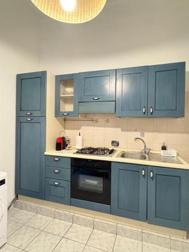 a kitchen with blue cabinets and a sink at Blue House in Turin