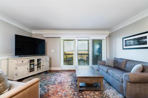 a living room with a couch and a tv at 1307 Pelican Watch Villa in Seabrook Island