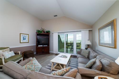 a living room with couches and a tv at 1304 Pelican Watch Villa in Seabrook Island