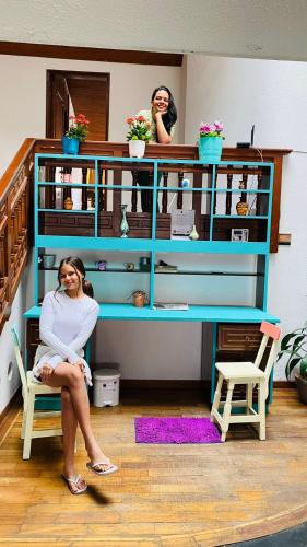 a woman sitting on a chair in front of a desk at Hostal Casalé Usaquén Embajada de Mexico in Bogotá
