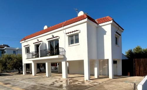 a white house with a red roof at Teak Charm in Larnaka