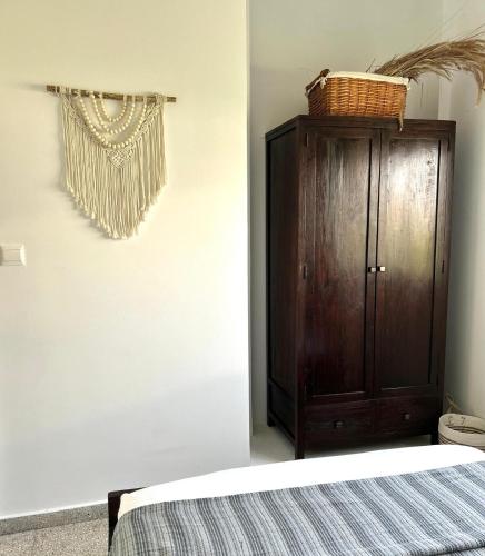 a bedroom with a bed and a wooden cabinet at Teak Charm in Larnaka