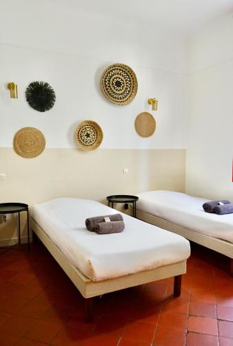 - 2 lits dans une chambre avec chapeaux sur le mur dans l'établissement LA CASA DINA, à Banyuls-sur-Mer