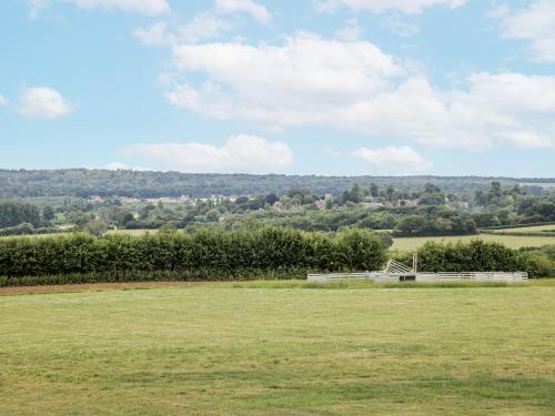 a field of grass with a building in the distance at The Hayloft in Calne