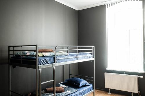 two bunk beds in a room with gray walls at Hedgehogs backpackers hostel in Rīga