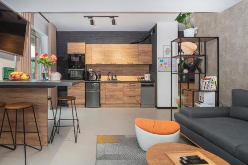 a kitchen and a living room with a couch at Premium Apartment Eleven in Zator