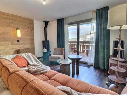 d'un salon avec un canapé et un balcon. dans l'établissement 3 pièces cabine moderne - Proche pistes & commerces, parking inclus, non-fumeur - FR-1-182-262, à Les Allues